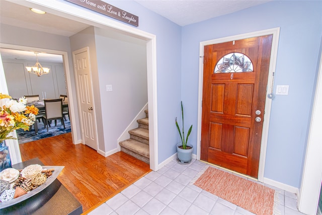 entrance foyer with an inviting chandelier and light hardwood / wood-style flooring