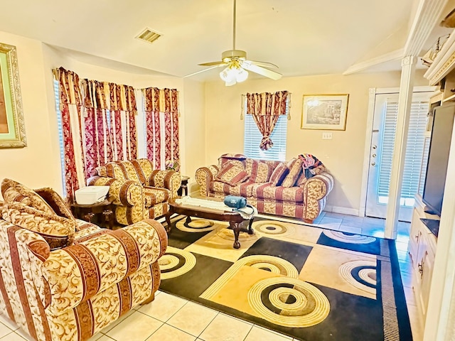 living room with lofted ceiling, light tile patterned flooring, and ceiling fan