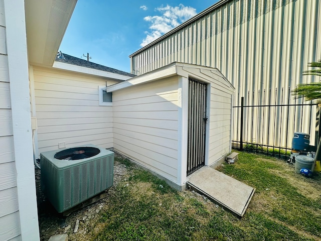 view of property exterior with a yard and central air condition unit