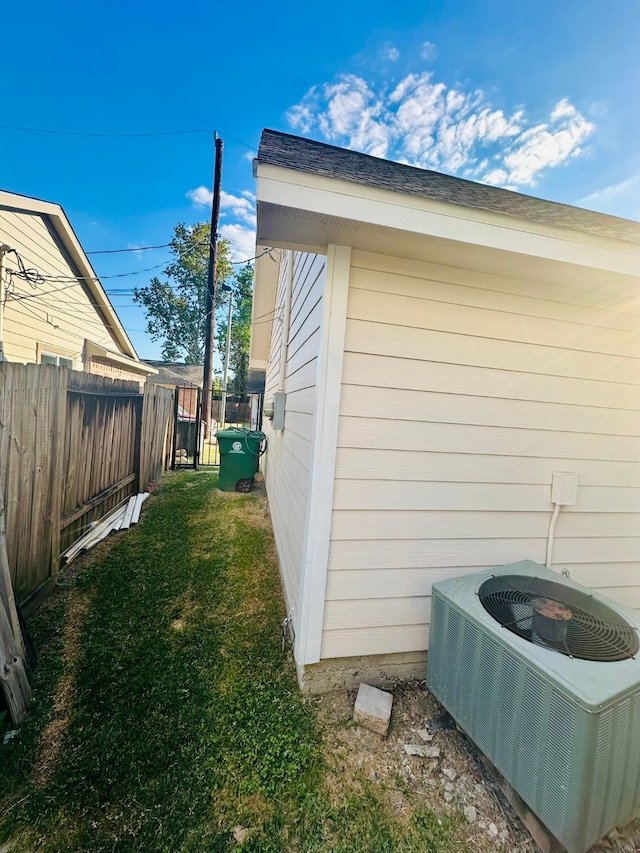 view of side of property with central AC unit and a yard