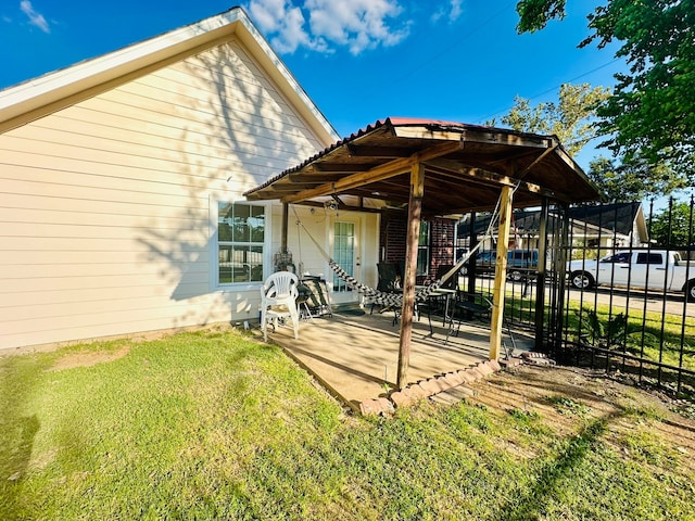 rear view of house featuring a lawn and a patio