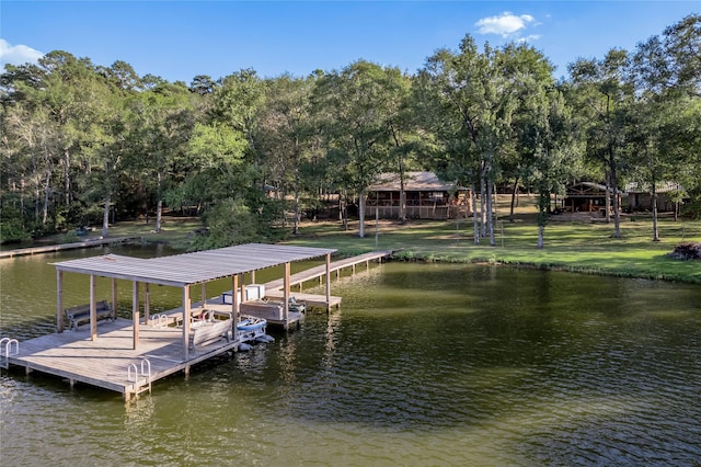 view of dock featuring a lawn, boat lift, and a water view
