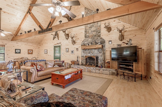living room featuring wood ceiling, wood walls, beamed ceiling, and ceiling fan