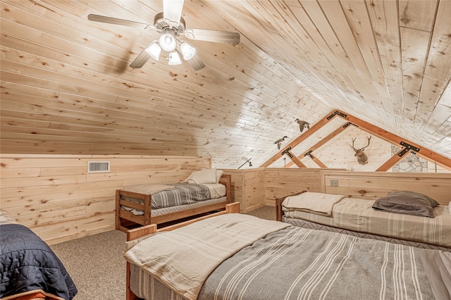 carpeted bedroom with lofted ceiling, wood ceiling, wood walls, and ceiling fan