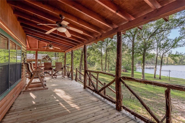 wooden terrace featuring a lawn, a water view, and ceiling fan