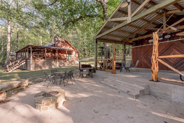 view of patio with an outdoor fire pit, outdoor dining area, and stairs