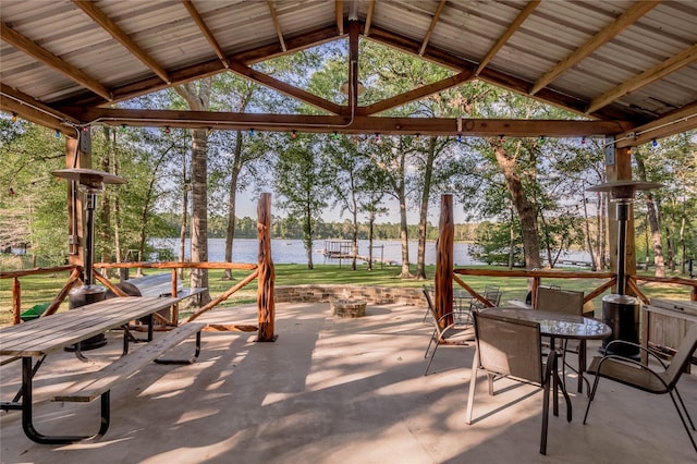 view of patio / terrace featuring a fire pit, outdoor dining area, and a water view