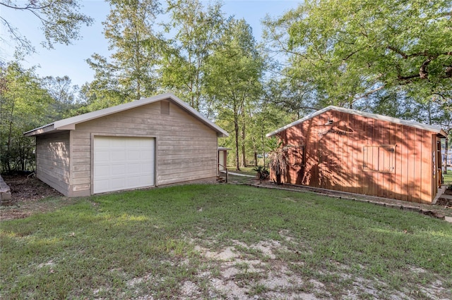 view of yard with a garage and an outbuilding