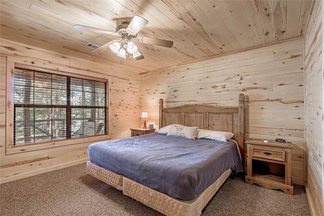 carpeted bedroom featuring ceiling fan, wooden ceiling, and wood walls
