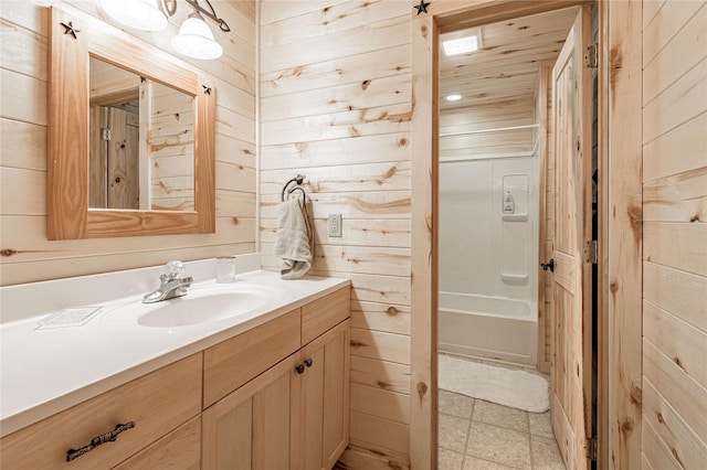 bathroom featuring shower / tub combination, wood walls, and vanity