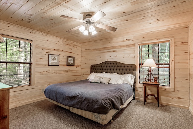 carpeted bedroom with wooden ceiling, wood walls, and ceiling fan