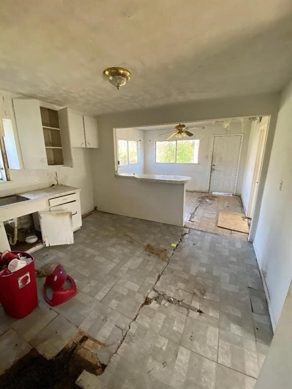 kitchen with ceiling fan and white cabinets