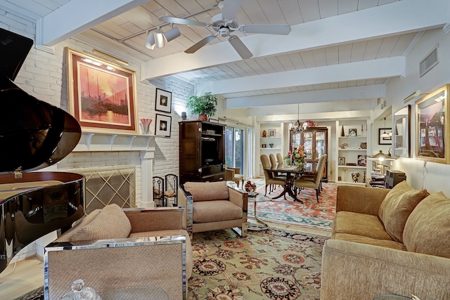 living room featuring wood ceiling, beamed ceiling, ceiling fan with notable chandelier, a fireplace, and brick wall