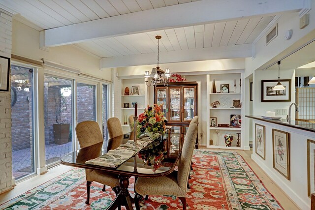 dining space with built in shelves, beamed ceiling, a notable chandelier, and wooden ceiling