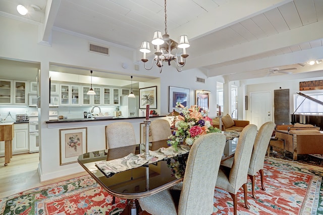 dining area featuring light wood-type flooring, sink, ceiling fan with notable chandelier, beam ceiling, and crown molding