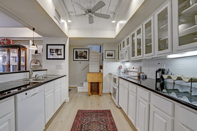 kitchen featuring white appliances, sink, tasteful backsplash, and white cabinets