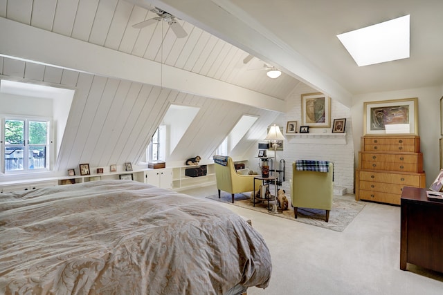 carpeted bedroom with vaulted ceiling with skylight, wooden walls, and ceiling fan