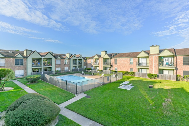 view of home's community featuring a pool and a yard