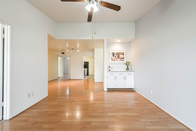 unfurnished living room with light wood-type flooring and ceiling fan