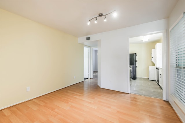 spare room with light wood-type flooring and washer / dryer