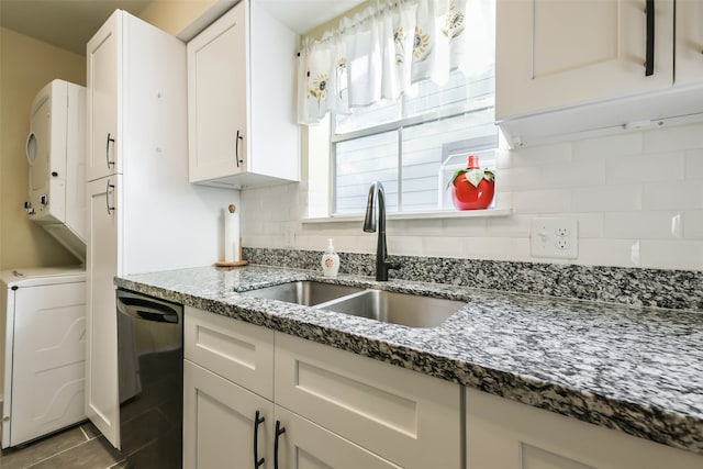 kitchen featuring black dishwasher, tasteful backsplash, sink, white cabinets, and dark stone countertops