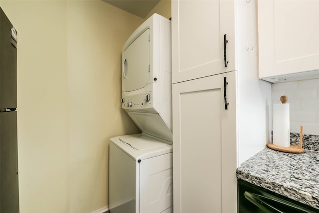 clothes washing area with stacked washer / dryer