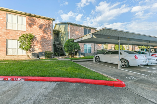 view of vehicle parking featuring a carport and a yard