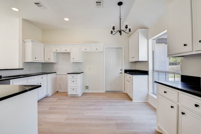 kitchen with a chandelier, pendant lighting, white cabinets, and light hardwood / wood-style floors