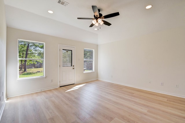 empty room with ceiling fan, a healthy amount of sunlight, and light hardwood / wood-style flooring