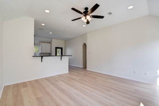 unfurnished living room with ceiling fan, light hardwood / wood-style floors, and vaulted ceiling