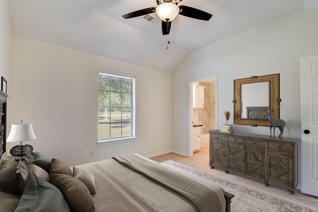 bedroom with ensuite bath, ceiling fan, light hardwood / wood-style floors, and vaulted ceiling