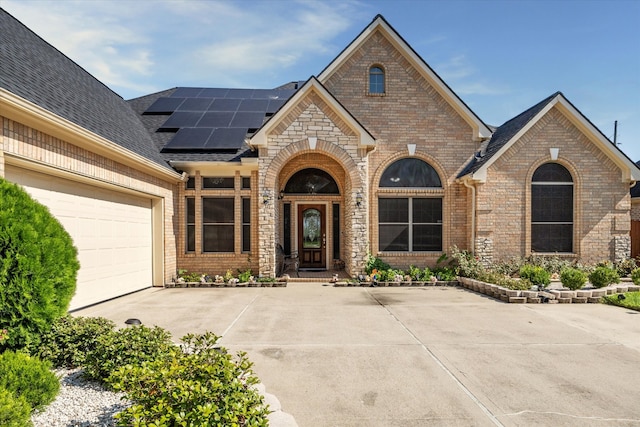 view of front of property featuring solar panels and a garage