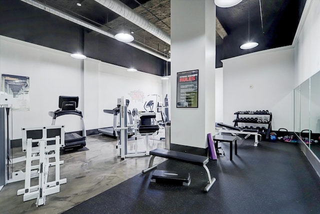 exercise room featuring a towering ceiling