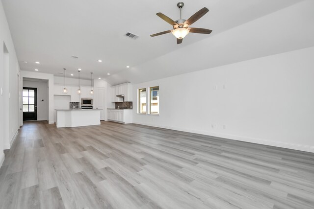 unfurnished living room featuring ceiling fan, light hardwood / wood-style floors, and a wealth of natural light