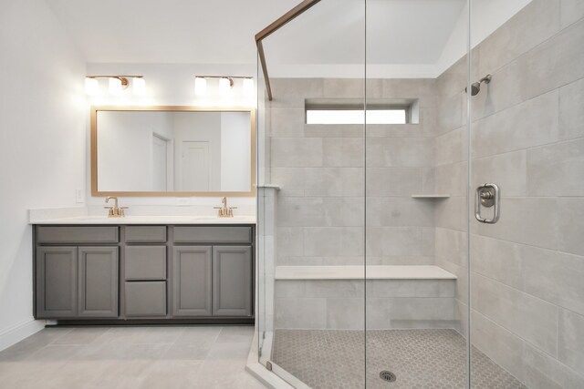 bathroom with walk in shower, vanity, and tile patterned floors