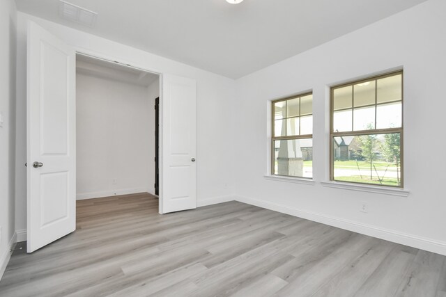 unfurnished bedroom featuring light hardwood / wood-style flooring and a closet