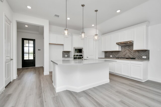 kitchen with a center island with sink, white cabinetry, light hardwood / wood-style flooring, and pendant lighting