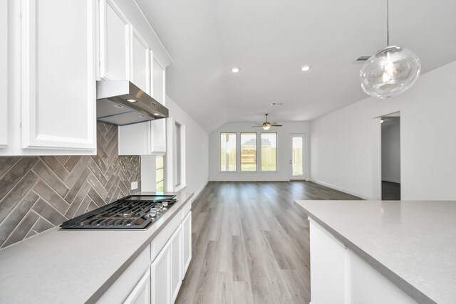 kitchen with white cabinets, tasteful backsplash, pendant lighting, light hardwood / wood-style flooring, and range hood