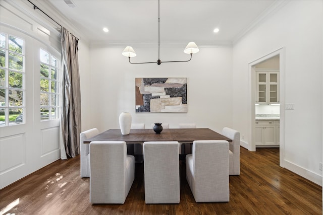 dining space with ornamental molding and dark hardwood / wood-style floors