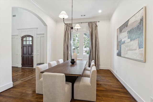 dining area featuring ornamental molding and dark hardwood / wood-style flooring