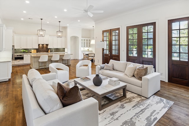 living room with french doors, ceiling fan, wood-type flooring, and ornamental molding