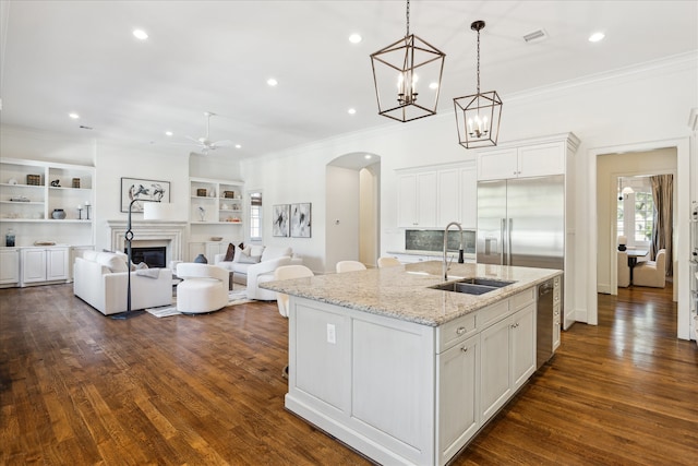 kitchen featuring dark wood-type flooring, white cabinetry, sink, and a center island with sink