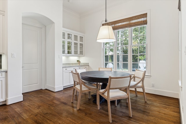 dining area featuring crown molding and dark wood-type flooring