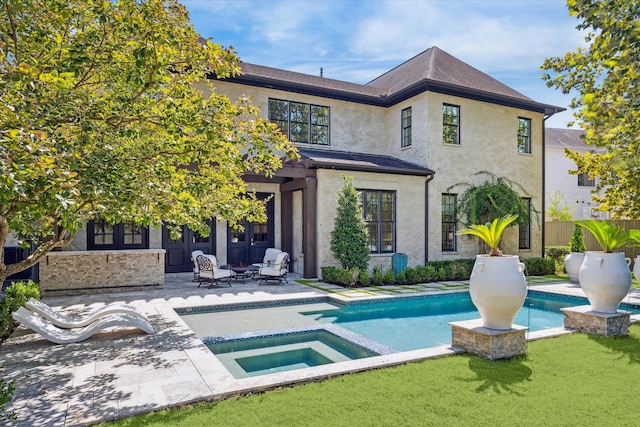 back of house with a patio, a lawn, and a swimming pool with hot tub