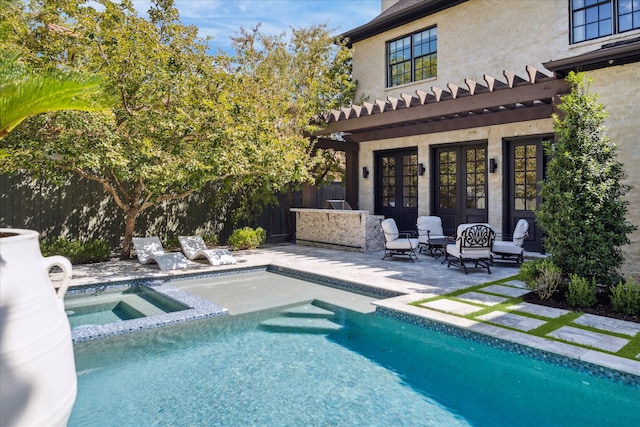 view of pool with an in ground hot tub, a patio area, and french doors