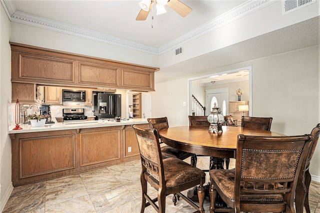 dining area featuring ceiling fan, sink, and ornamental molding