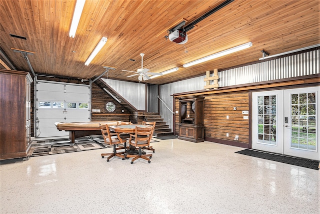 garage featuring french doors, wood ceiling, ceiling fan, a garage door opener, and wood walls