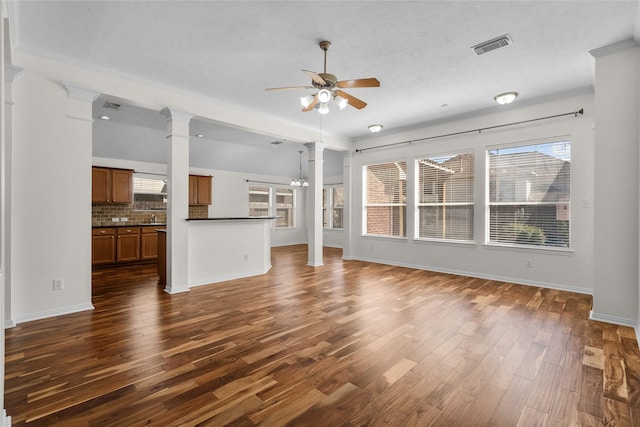 unfurnished living room with ceiling fan, dark wood-type flooring, and decorative columns