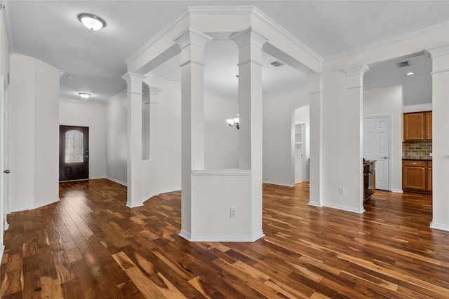 entryway featuring a chandelier, dark wood-type flooring, and ornamental molding