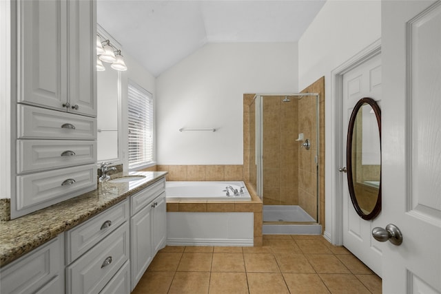 bathroom featuring tile patterned flooring, vanity, independent shower and bath, and vaulted ceiling